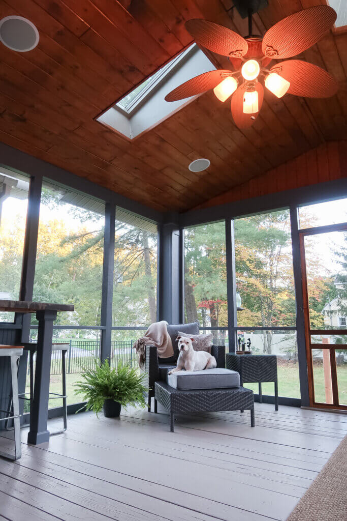 Enclosed patio with dog sitting on ottoman